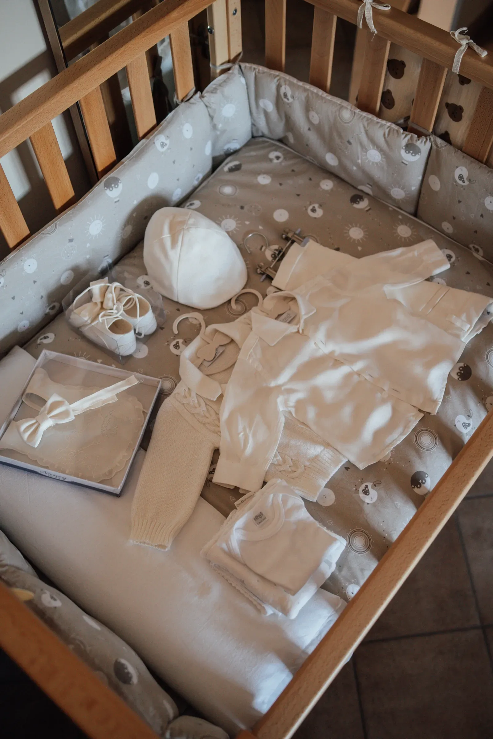 Abito e accessori del battesimo preparati nella culla