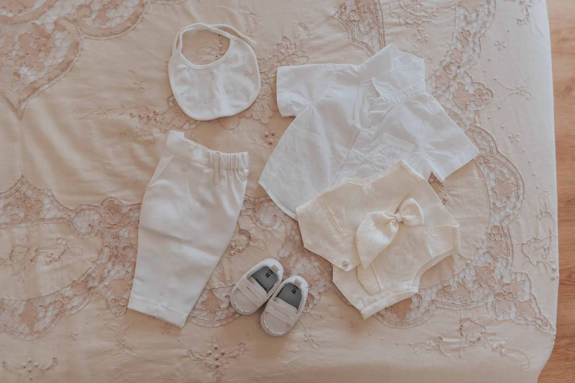 Vestitino, bavaglino e scarpine del battesimo pronti prima della vestizione